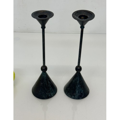 72 - A pair of patinated candlestands of a geometric design, 24 cm tall.

This lot is available for in-ho... 