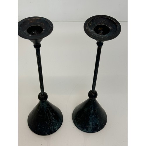 72 - A pair of patinated candlestands of a geometric design, 24 cm tall.

This lot is available for in-ho... 