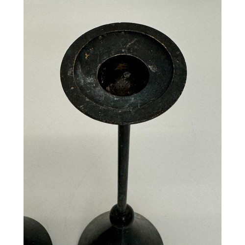 72 - A pair of patinated candlestands of a geometric design, 24 cm tall.

This lot is available for in-ho... 