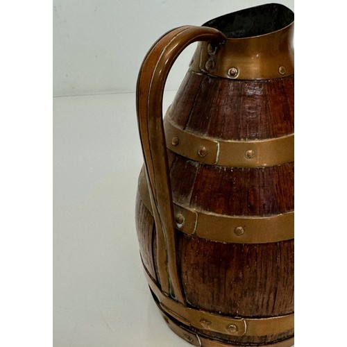 167 - A coopered oak jug with copper bindings, 20 cm tall.

This lot is available for in-house shipping