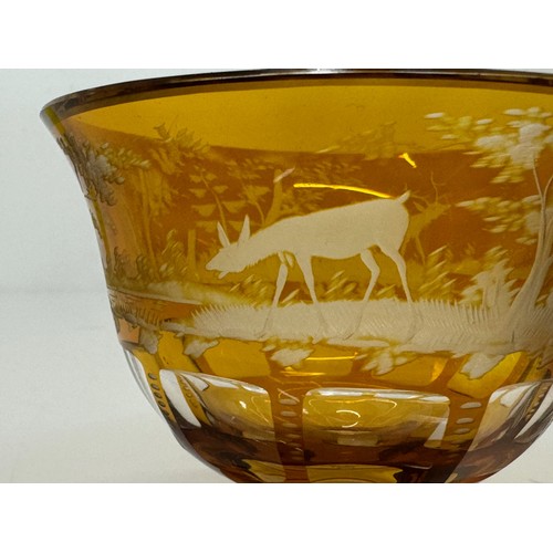 193 - Wheel cut amber glass bowl decorated with deer in a woodland setting, 13 cm diameter x 10.5 cm high.... 