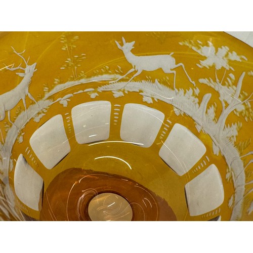 193 - Wheel cut amber glass bowl decorated with deer in a woodland setting, 13 cm diameter x 10.5 cm high.... 