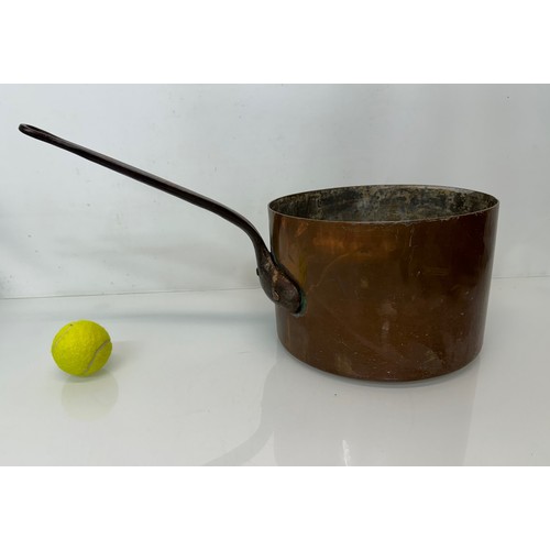 15 - Kitchenalia, a large  and very weighty copper saucepan, 28 cm in diameter x 20 cm deep and 58 cm lon... 