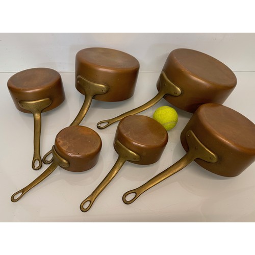 18 - Copper saucepans, a graduated set of six copper saucepans with cast brass handles, 10cm, 12cm, 14 cm... 