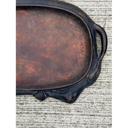 96 - Cast iron dish fitted within the centre of a seated cow form, 32 cm x 22cm 

This lot is available f... 