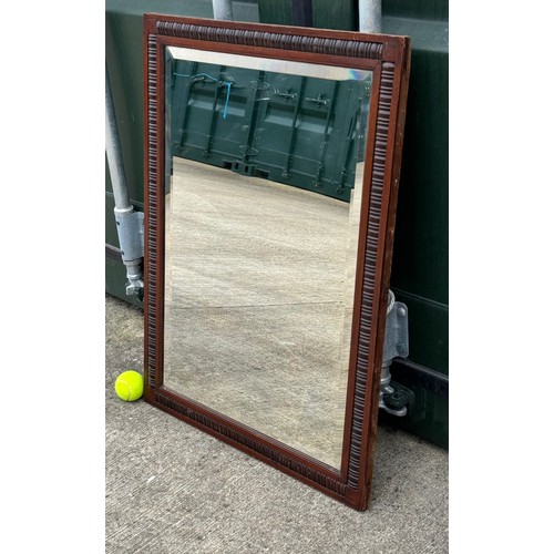 100 - Edwardian bevel edged wall mirror in a decorative wooden frame, 61 cm x 81 cm.

This lot is collecti... 