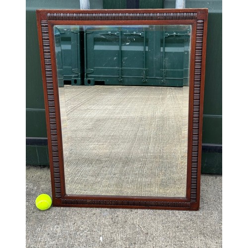 100 - Edwardian bevel edged wall mirror in a decorative wooden frame, 61 cm x 81 cm.

This lot is collecti... 