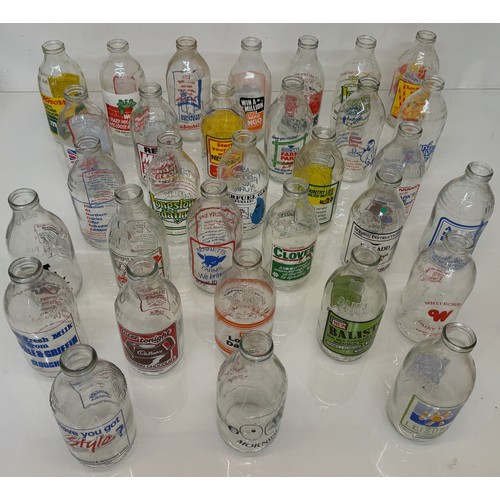 164 - A collection of advertising themed glass milk bottles.

This lot is available for in-house shipping