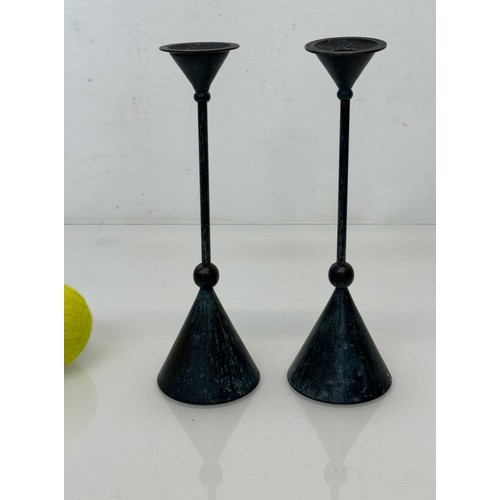 88 - A pair of patinated candlestands of a geometric design, 24 cm tall.

This lot is available for in-ho... 