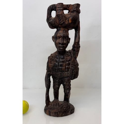 12 - African folk art, hand carved hardwood figure of an elephant  hunter / poacher, 52 cm high.

This lo... 