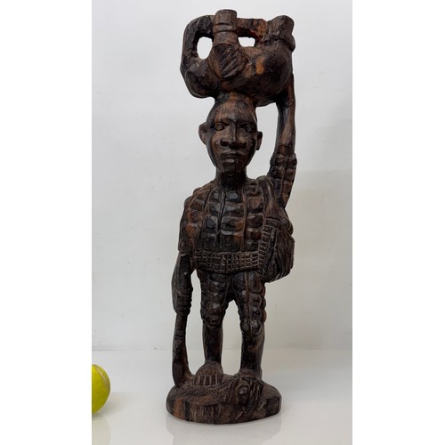 12 - African folk art, hand carved hardwood figure of an elephant  hunter / poacher, 52 cm high.

This lo... 