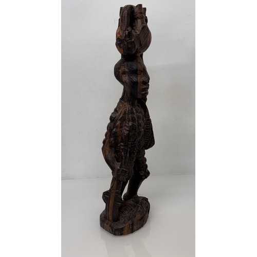 12 - African folk art, hand carved hardwood figure of an elephant  hunter / poacher, 52 cm high.

This lo... 