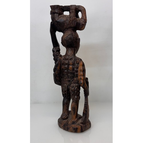 12 - African folk art, hand carved hardwood figure of an elephant  hunter / poacher, 52 cm high.

This lo... 