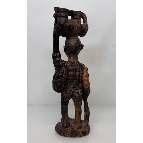 12 - African folk art, hand carved hardwood figure of an elephant  hunter / poacher, 52 cm high.

This lo... 