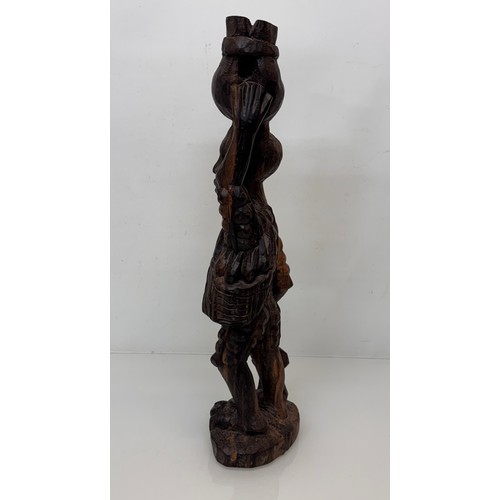 12 - African folk art, hand carved hardwood figure of an elephant  hunter / poacher, 52 cm high.

This lo... 