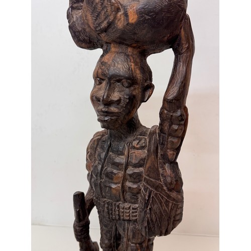 12 - African folk art, hand carved hardwood figure of an elephant  hunter / poacher, 52 cm high.

This lo... 