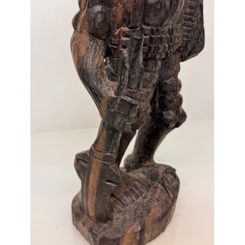 12 - African folk art, hand carved hardwood figure of an elephant  hunter / poacher, 52 cm high.

This lo... 