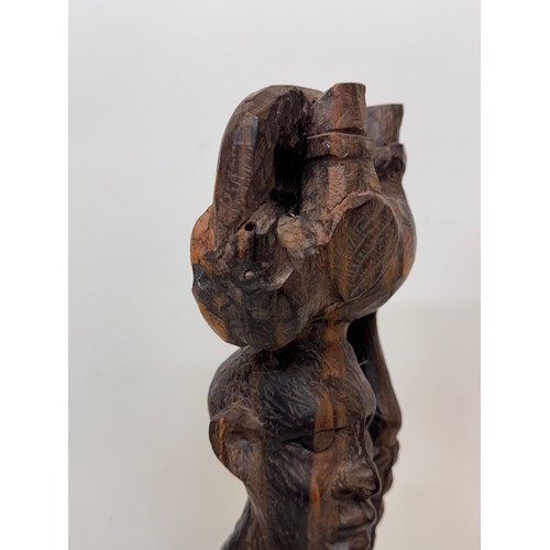 12 - African folk art, hand carved hardwood figure of an elephant  hunter / poacher, 52 cm high.

This lo... 