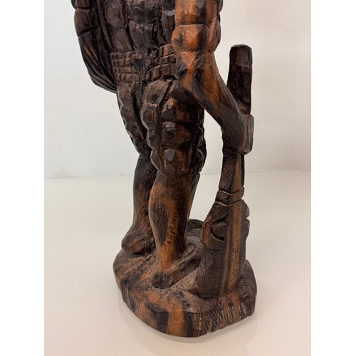 12 - African folk art, hand carved hardwood figure of an elephant  hunter / poacher, 52 cm high.

This lo... 