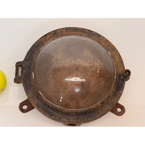 215 - Industrial lighting, a cast iron 9 inch diameter bulkhead light unit.

This lot is available for in-... 