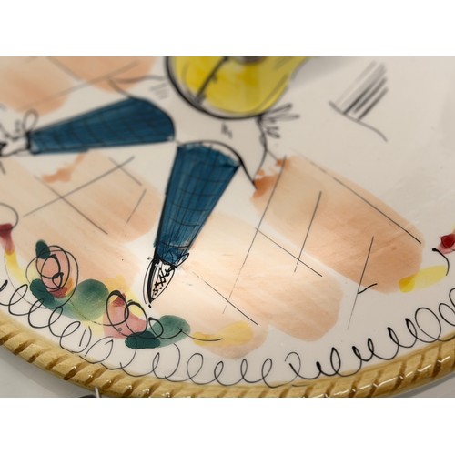 381 - Mid century table wares, a kitch serving platter decorated with an image of a jolly chef, 21 cm in d... 