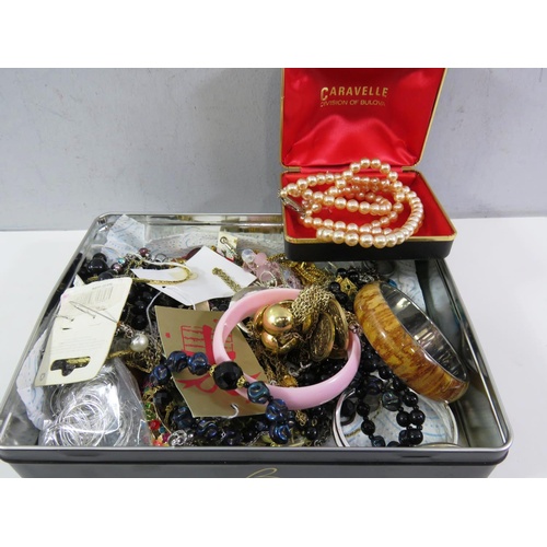 437 - TIN OF COSTUME JEWELLERY