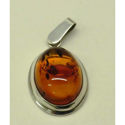 513 - TWO 925 SILVER AND AMBER PENDANTS