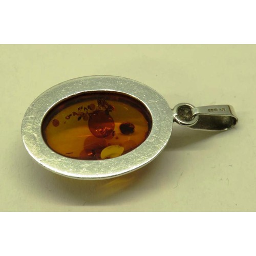 513 - TWO 925 SILVER AND AMBER PENDANTS