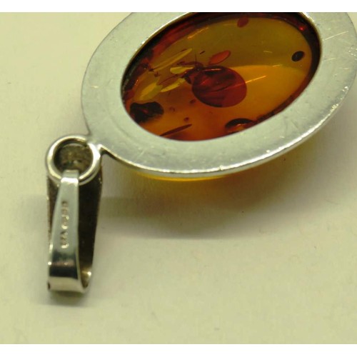 513 - TWO 925 SILVER AND AMBER PENDANTS