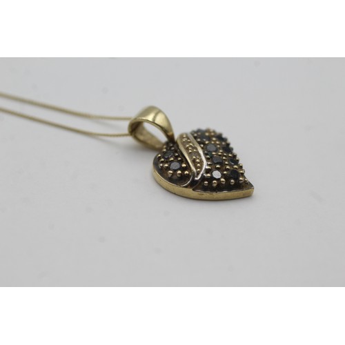 492 - 9ct gold diamond & black diamond heart pendant necklace (2.7g)