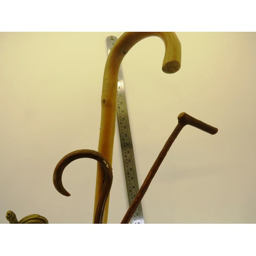 207 - ORNATE BRASS WALKING STICK STAND AND THREE WALKING STICKS/CANES