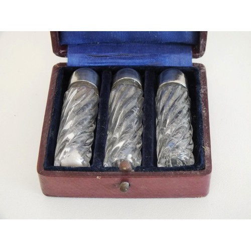 4 - SET OF THREE GLASS SCENT BOTTLES WITH SILVERPLATE TOPS IN A RED LEATHER BOUND PRESENTATION BOX & SET... 