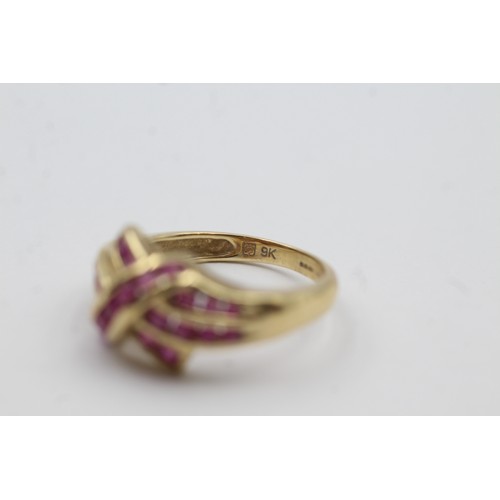 472 - 9ct gold ruby channel set twist ring (3.1g)- SIZE N