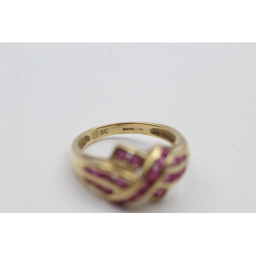 472 - 9ct gold ruby channel set twist ring (3.1g)- SIZE N