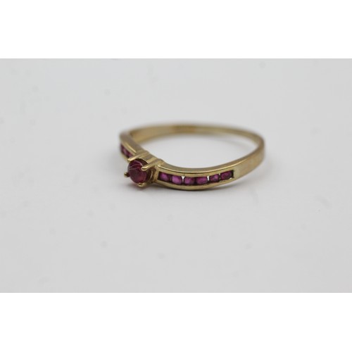 474 - 9ct gold ruby channel shoulder setting ring (1.4g)- SIZE O