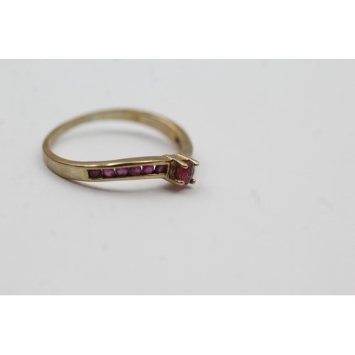 474 - 9ct gold ruby channel shoulder setting ring (1.4g)- SIZE O