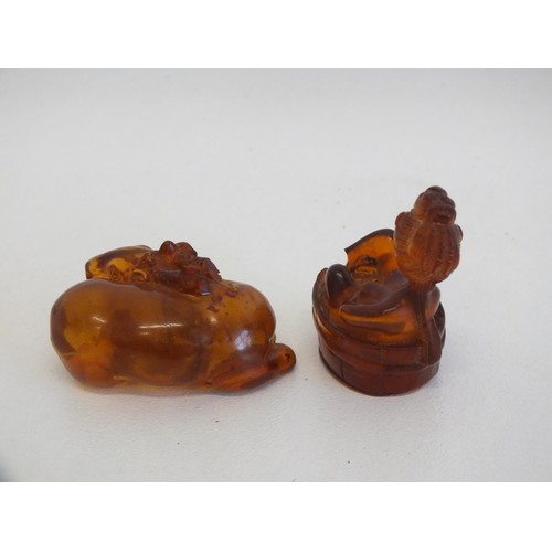 274 - 2 AMBER NETSUKES INCLUDES JAPANESE LADY IN A BATH TUB (AS FOUND) and A PIECE OF NATURAL RAW AMBER AP... 