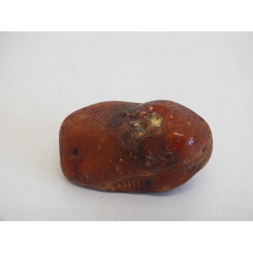 274 - 2 AMBER NETSUKES INCLUDES JAPANESE LADY IN A BATH TUB (AS FOUND) and A PIECE OF NATURAL RAW AMBER AP... 