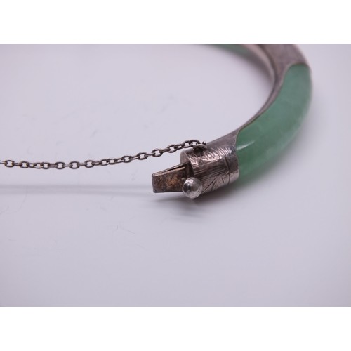 240 - ORIENTAL NATURAL JADE AND STERLING SILVER BANGLE WITH SAFETY CHAIN