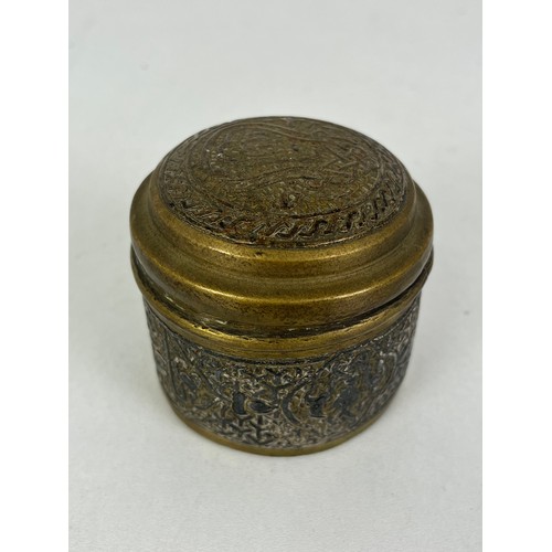 270 - CAIRO WARE CIRCULAR BRASS TRINKET BOX INLAID WITH SILVER ISLAMIC SCRIPT, height 5cms width 6.5cms