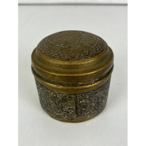 270 - CAIRO WARE CIRCULAR BRASS TRINKET BOX INLAID WITH SILVER ISLAMIC SCRIPT, height 5cms width 6.5cms