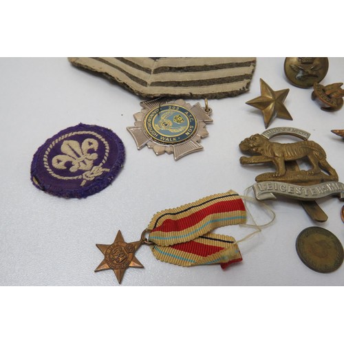 45 - Collection of Military cloth badges, cap badges etc in a leather pouch.