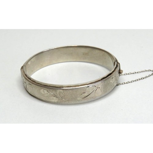 119 - Silver hinged bangle with safety chain.