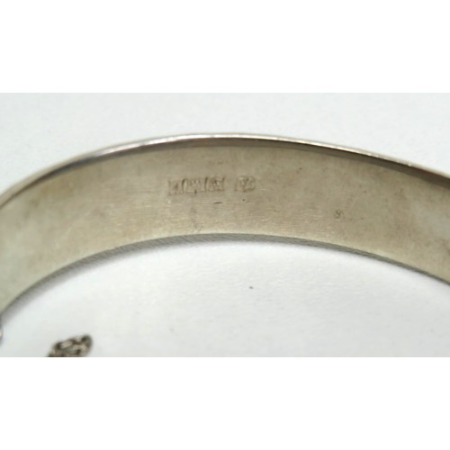 119 - Silver hinged bangle with safety chain.