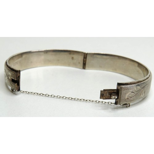 119 - Silver hinged bangle with safety chain.