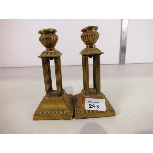 283 - A pair of antique brass column candlesticks.