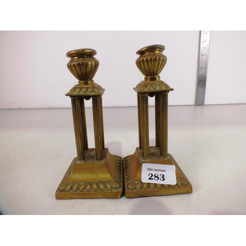 283 - A pair of antique brass column candlesticks.