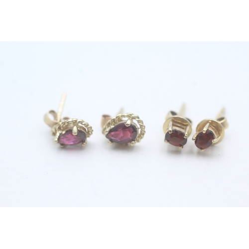 493 - Two pairs of 9ct gold and garnet stud earrings (2g)