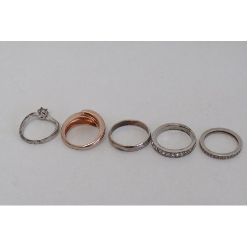 235 - Four silver rings and a white metal ring