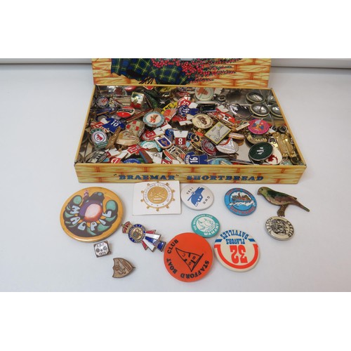 43 - 100 Badges in old tin, magpie, football, curling etc